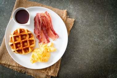 Kahvaltı için çırpılmış yumurta, pastırma ve waffle.