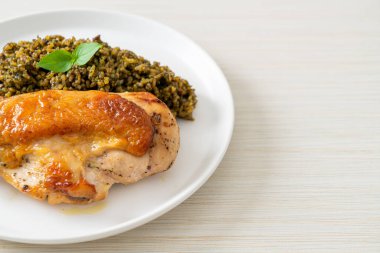 Kızarmış pesto pilavı ve beyaz tabakta kızarmış tavuk.