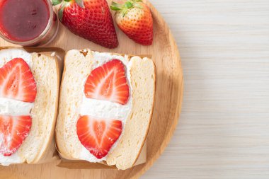 gözlemeli sandviç, çilekli taze krema, ahşap tabakta.