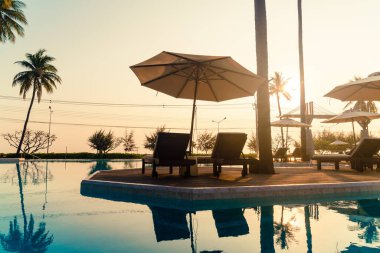 Okyanus geçmişi olan yüzme havuzunun etrafında havuzu olan şemsiyeler - tatil ve tatil kavramı