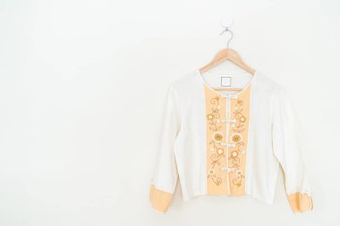 Duvarında ahşap askı asılı güzel bir kadın gömleği.