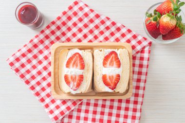 gözlemeli sandviç, çilekli taze krema, ahşap tabakta.