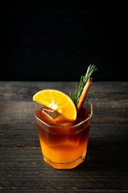 Bir bardak buzlu americano sade kahve ve biberiye ve tarçınla süslenmiş portakal ve limon suyu.