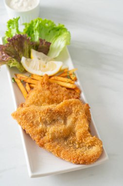 balık ve patates kızartması - kızarmış balık fileto patates cipsi ve limonlu beyaz tabak
