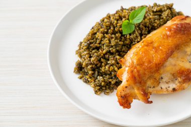 Kızarmış pesto pilavı ve beyaz tabakta kızarmış tavuk.