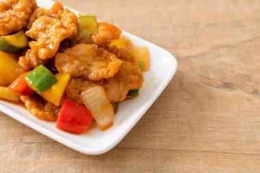 Kızarmış tatlı ve ekşi sosla domuz ve sebzeyi karıştır.