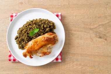 Kızarmış pesto pilavı ve beyaz tabakta kızarmış tavuk.