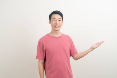 Beyaz arka planda eli işaret eden ya da sunan genç Asyalı adam portresi