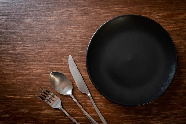 Άδειο Πιάτο Πιάτο Μαχαίρι Πιρούνι Και Κουτάλι Ξύλινο Φόντο Πλακιδίων — Φωτογραφία Αρχείου