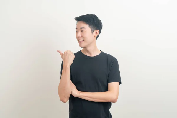 손으로 가리키거나 배경을 제시하는 아시아 청년을 — 스톡 사진