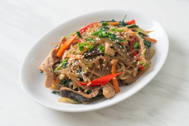 Japchae ya da karışık Kore vermicelli erişte sebzeli ve üzerine beyaz susamlı domuz eti - Kore geleneksel yemek tarzı