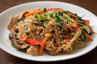 Japchae ya da karışık Kore vermicelli erişte sebzeli ve üzerine beyaz susamlı domuz eti - Kore geleneksel yemek tarzı