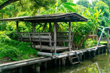 Küçük kanalın yanında ahşap pavyon.