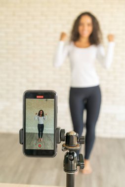 Latin kadın nüfuzlu kişi dans videosunu akıllı telefon kamerasıyla oluşturdu. Videoyu sosyal medya uygulamasına paylaşmak için.