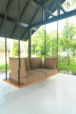 Boş kanepe dinlenmek için bahçede sallanıyor.