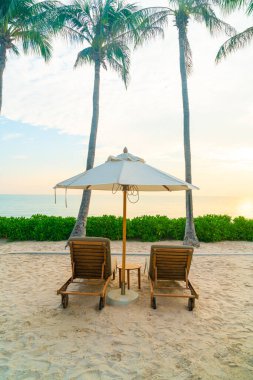 Plaj sandalyesi ve okyanus geçmişi olan şemsiye - tatil ve tatil kavramı