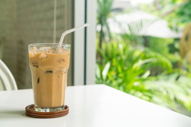 Kahve dükkanındaki masada buzlu kahve bardağı var.