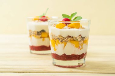 Ev yapımı taze mango ve yoğurt ve granola ile taze ahududu. Sağlıklı yemek tarzı.