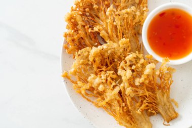 Kızarmış enoki mantarı ya da baharatlı soslu altın iğneli mantar - vejetaryen yemek tarzı.