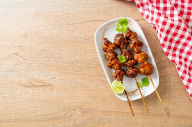 Izgara tavuk şişi. Tabakta baharat ve şifalı otlar var.