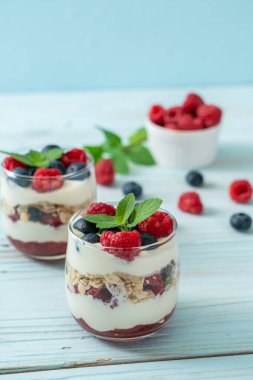 Ev yapımı ahududu ve yaban mersinli yoğurt ve granola. Sağlıklı yemek tarzı.