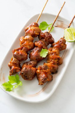 Izgara tavuk şişi. Tabakta baharat ve şifalı otlar var.