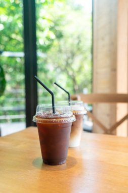 Kafe restoranının masasında kahve bardağında buzlu Americano kahvesi.