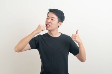 Genç Asyalı adam beyaz arka planda dişlerini fırçaladı.