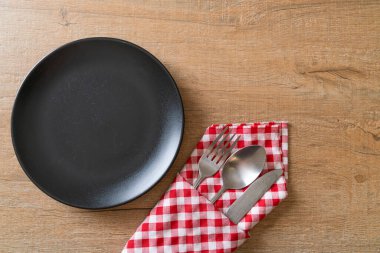 Ahşap zemin üzerinde bıçak, çatal ve kaşık olan boş tabak veya tabak