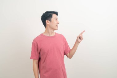 Beyaz arka planda eli işaret eden ya da sunan genç Asyalı adam portresi
