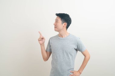 Beyaz arka planda eli işaret eden ya da sunan genç Asyalı adam portresi
