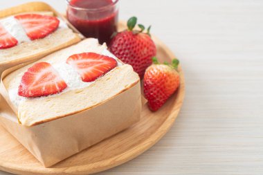 gözlemeli sandviç, çilekli taze krema, ahşap tabakta.