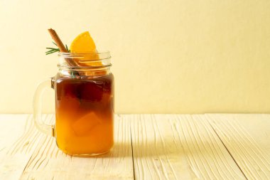 Bir bardak buzlu americano sade kahve ve biberiye ve tarçınla süslenmiş portakal ve limon suyu.