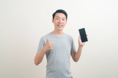 Beyaz arka planda akıllı telefon ve cep telefonu kullanan ya da konuşan genç Asyalı adam