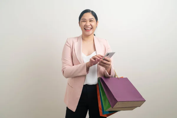 スマートフォンでショッピングバッグを手にするアジアの女性 オンラインショッピングコンセプト — ストック写真