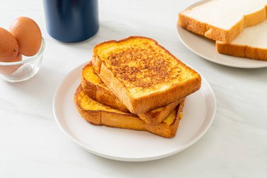 Kahvaltı için beyaz tabakta yumurtalı ekmek.