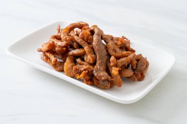 Beyaz tabakta kurutulmuş domuz eti, Asya yemeği tarzı.