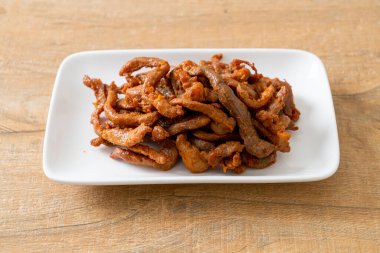 Beyaz tabakta kurutulmuş domuz eti, Asya yemeği tarzı.