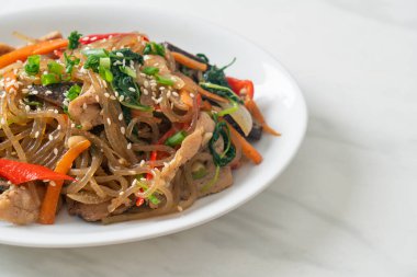 Japchae ya da karışık Kore vermicelli erişte sebzeli ve üzerine beyaz susamlı domuz eti - Kore geleneksel yemek tarzı