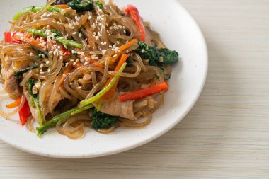 Japchae ya da karışık Kore vermicelli erişte sebzeli ve üzerine beyaz susamlı domuz eti - Kore geleneksel yemek tarzı