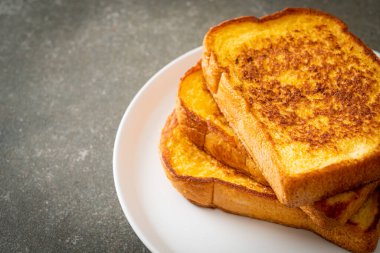 Kahvaltı için beyaz tabakta yumurtalı ekmek.