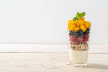 Ev yapımı mango, ahududu ve yaban mersinli yoğurt ve granola - sağlıklı yemek tarzı.