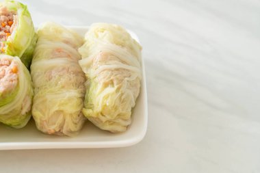 Çin lahanasına sarılı ev yapımı kıymalı domuz eti ya da haşlanmış lahana.