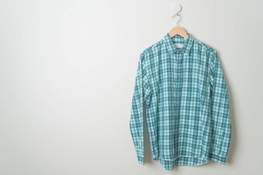 duvarında ahşap askı olan çizgili tişört