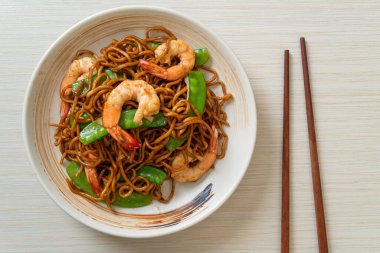 Kızarmış yakisoba eriştesi, yeşil bezelye ve karides, Asya usulü.