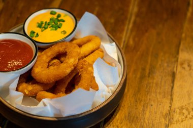 Ketçaplı soğan halkası ve tabakta sos.