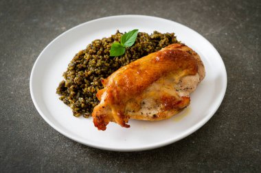 Kızarmış pesto pilavı ve beyaz tabakta kızarmış tavuk.