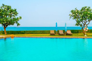 Havuz kenarındaki havuz, havuz, şemsiye, deniz manzaralı havuz tatilleri ve tatil konsepti.