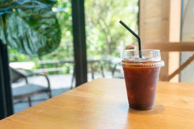 Kafe restoranının masasında kahve bardağında buzlu Americano kahvesi.