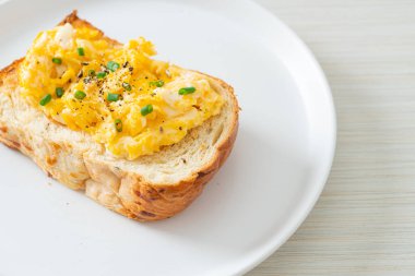 Ekmek tostu, çırpılmış yumurta ve beyaz tabak.